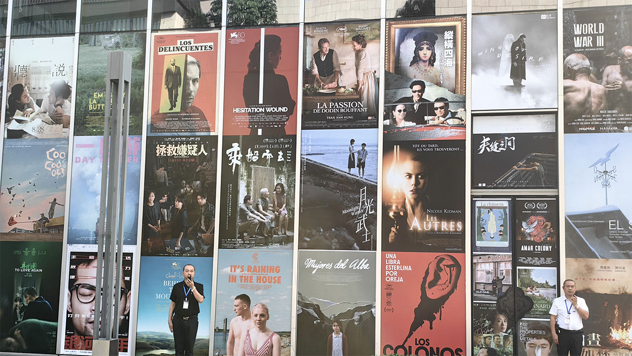 Security personnel using Lenovo intercoms at the 2023 Golden Rooster Awards in China amidst a backdrop of movie posters